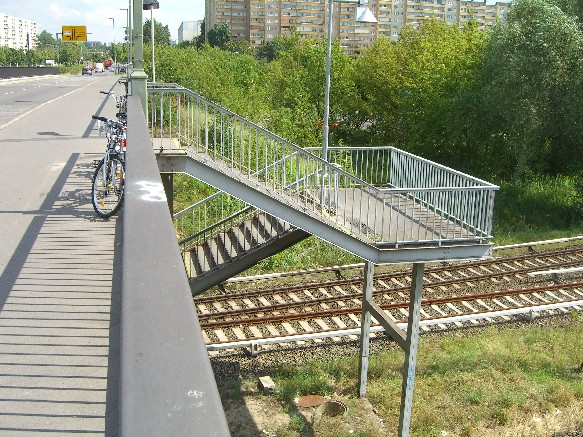 Über diese Brücke errecht man eine weitere Brücke die zwischen den S-Bahngleisen unter der großen Hauptbrüche quer liegt.Von dieser untergehangenen Brücke aus kann man sowohl den S-Bahnhof als auch die 2 Straßenbahnhaltestellen erreichen